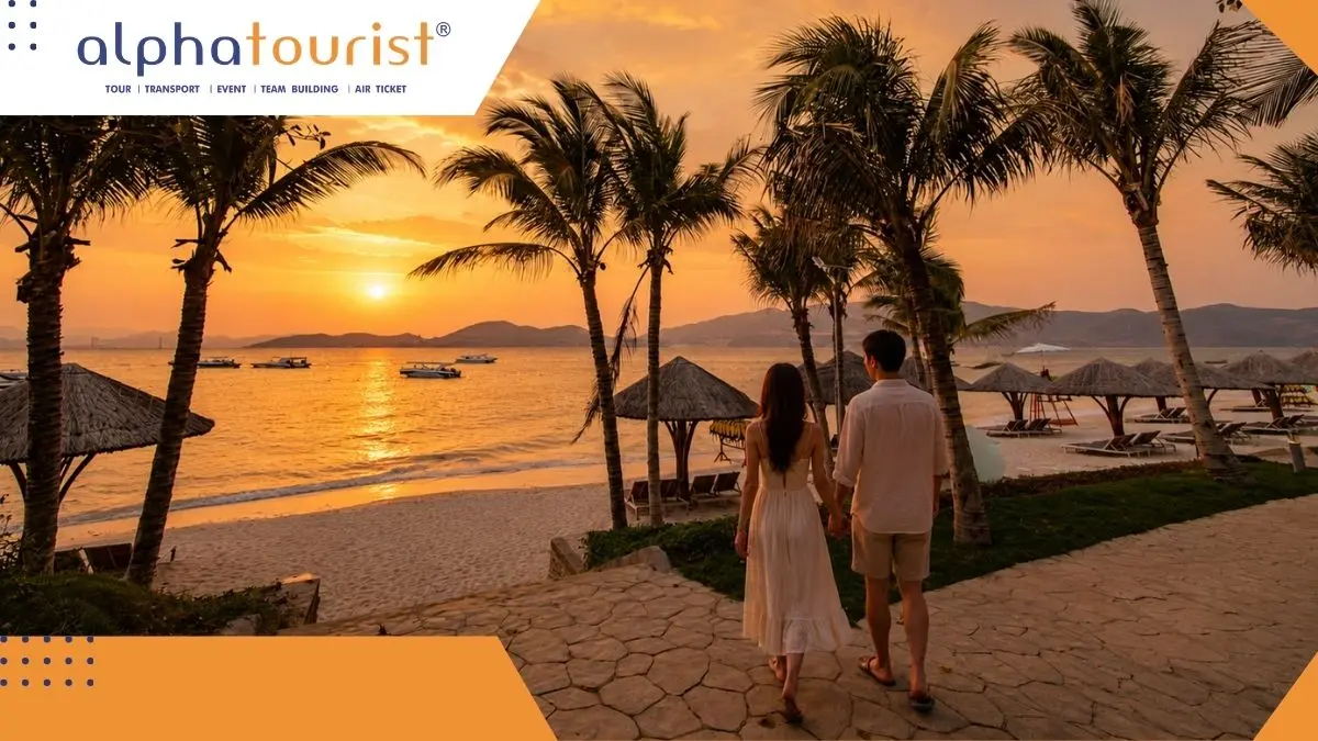 Một cặp đôi trẻ người Việt nắm tay nhau đi dạo trên bãi cát trắng mịn của Hòn Tằm, Nha Trang vào buổi chiều tà với ánh nắng vàng rực rỡ