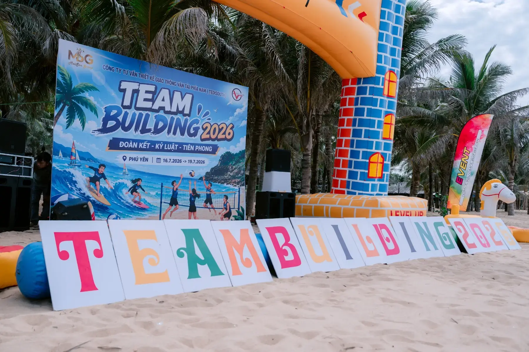 Cổng chào Team Building Phú Yên với backdrop chương trình và khu vực check-in trên bãi biển